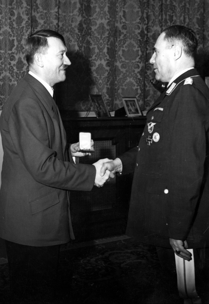 Adolf Hitler offers a party badge to general Karl Bodenschatz on the occasion of his 50th birthday